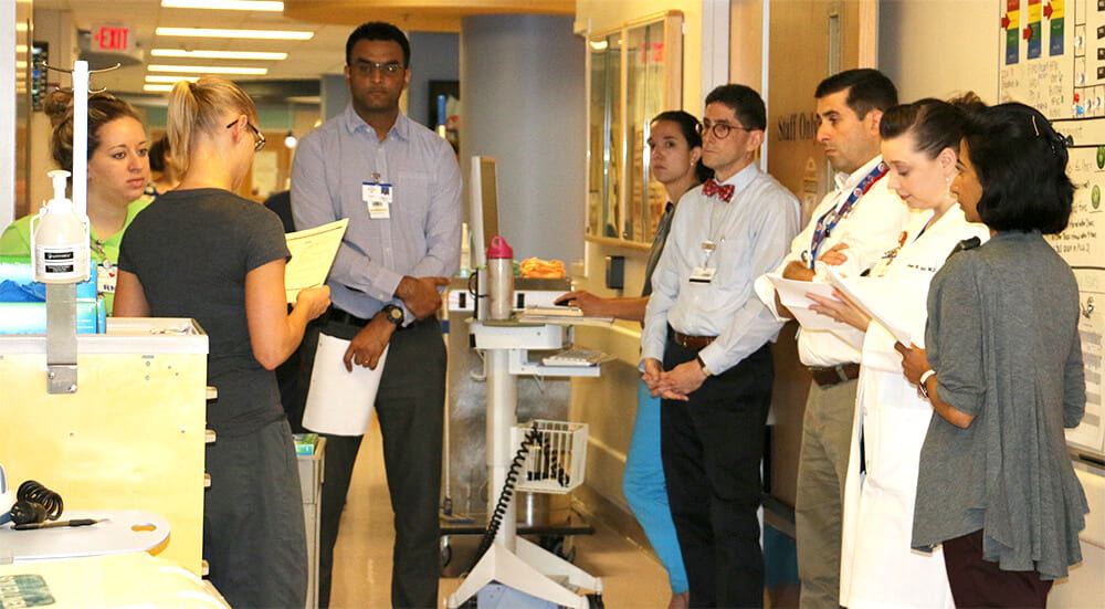 A number of Pediatric Critical Care Medicine fellows engaged in training in the halls of a hospital